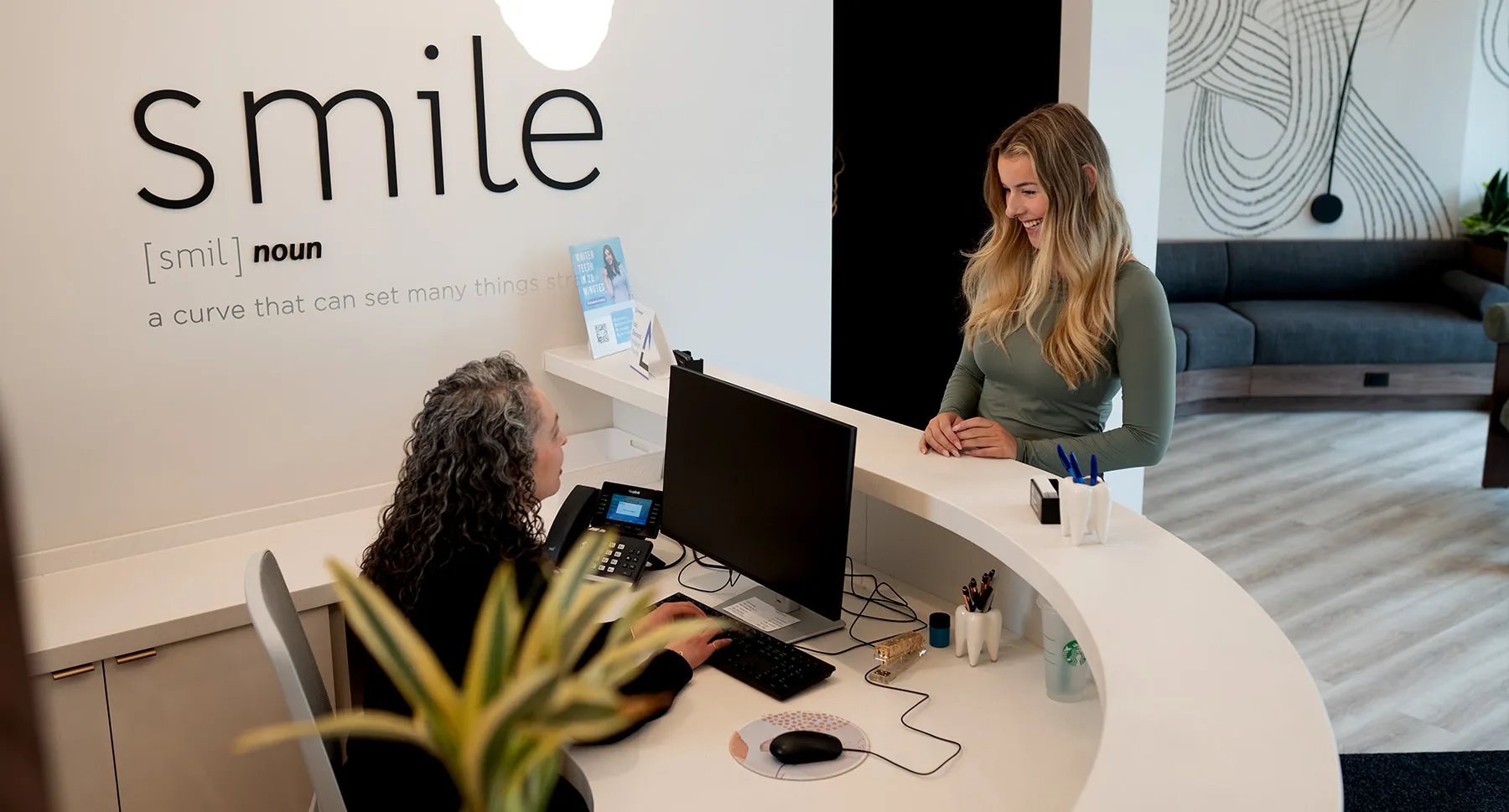 Staff greeting patient at the Mumford Road Clinic Reception Desk